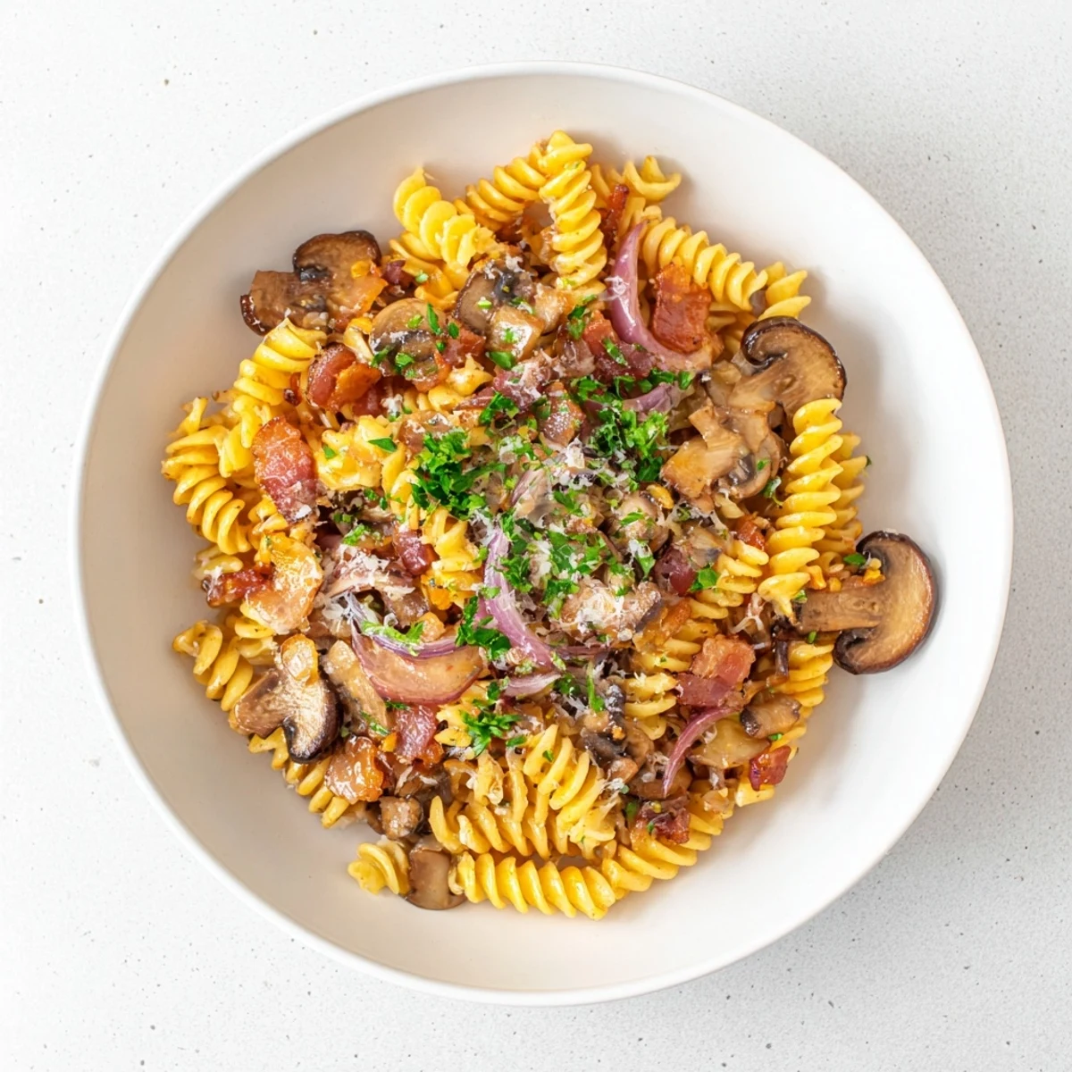Fusilli with bacon, onions, and mushrooms: A steaming bowl of pasta with crispy bacon.