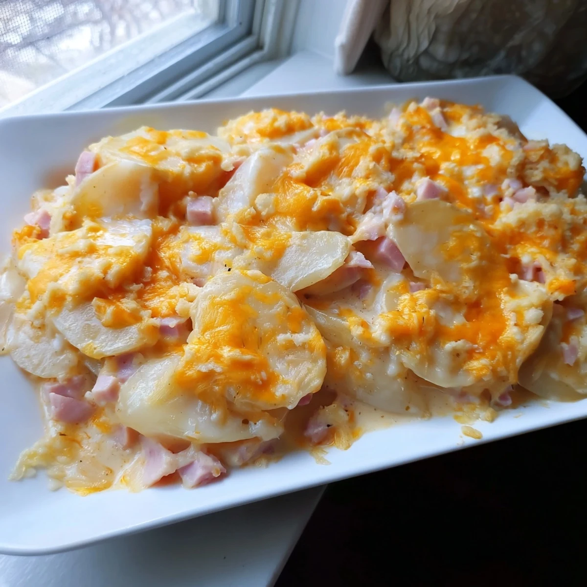 Savory Creamy Ham and Potato Scallop Casserole, a family-style dish with a creamy cheese sauce, ready to serve.