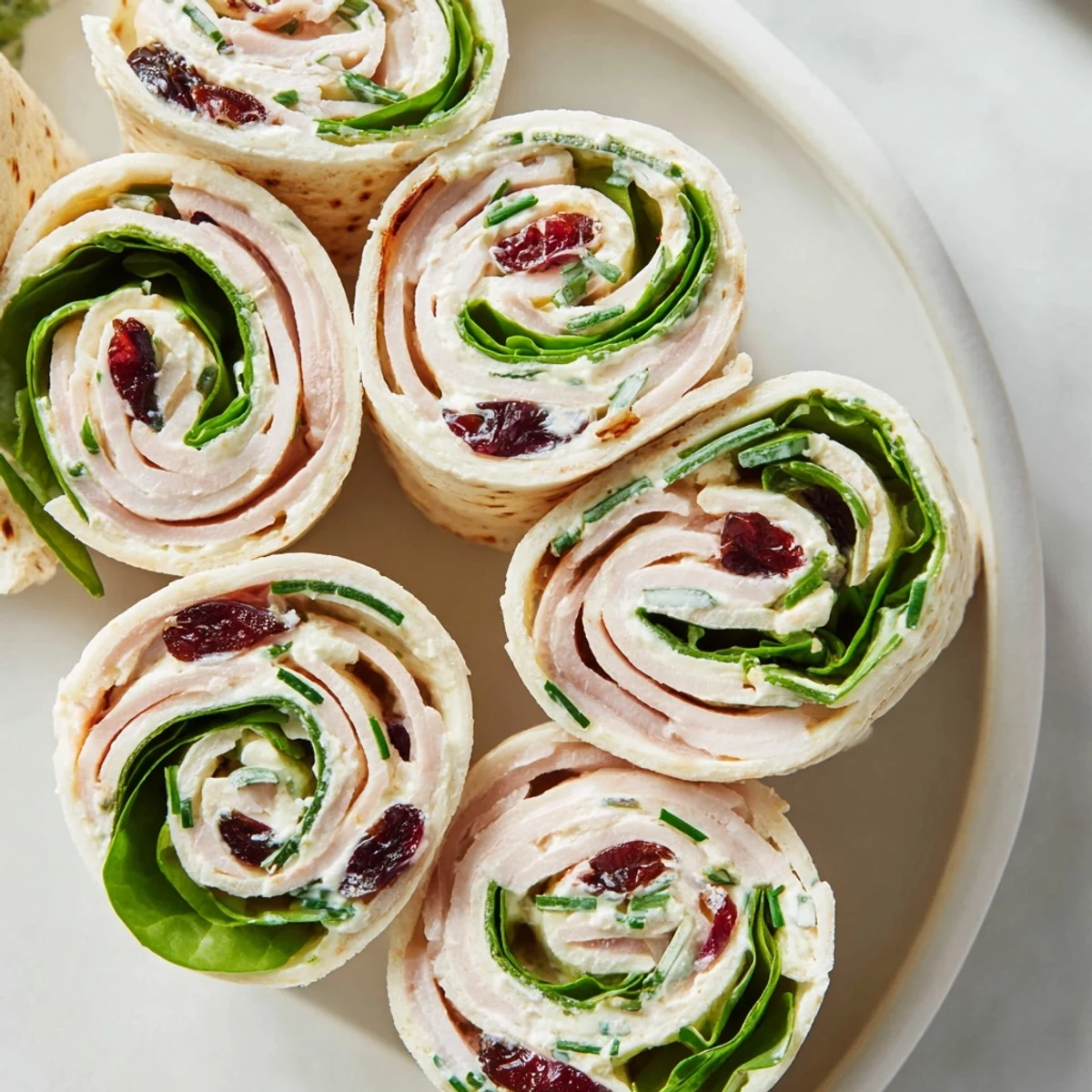 Delicious, festive Simplified Turkey Cranberry Pinwheels, layered with cranberry and turkey, ready to eat!