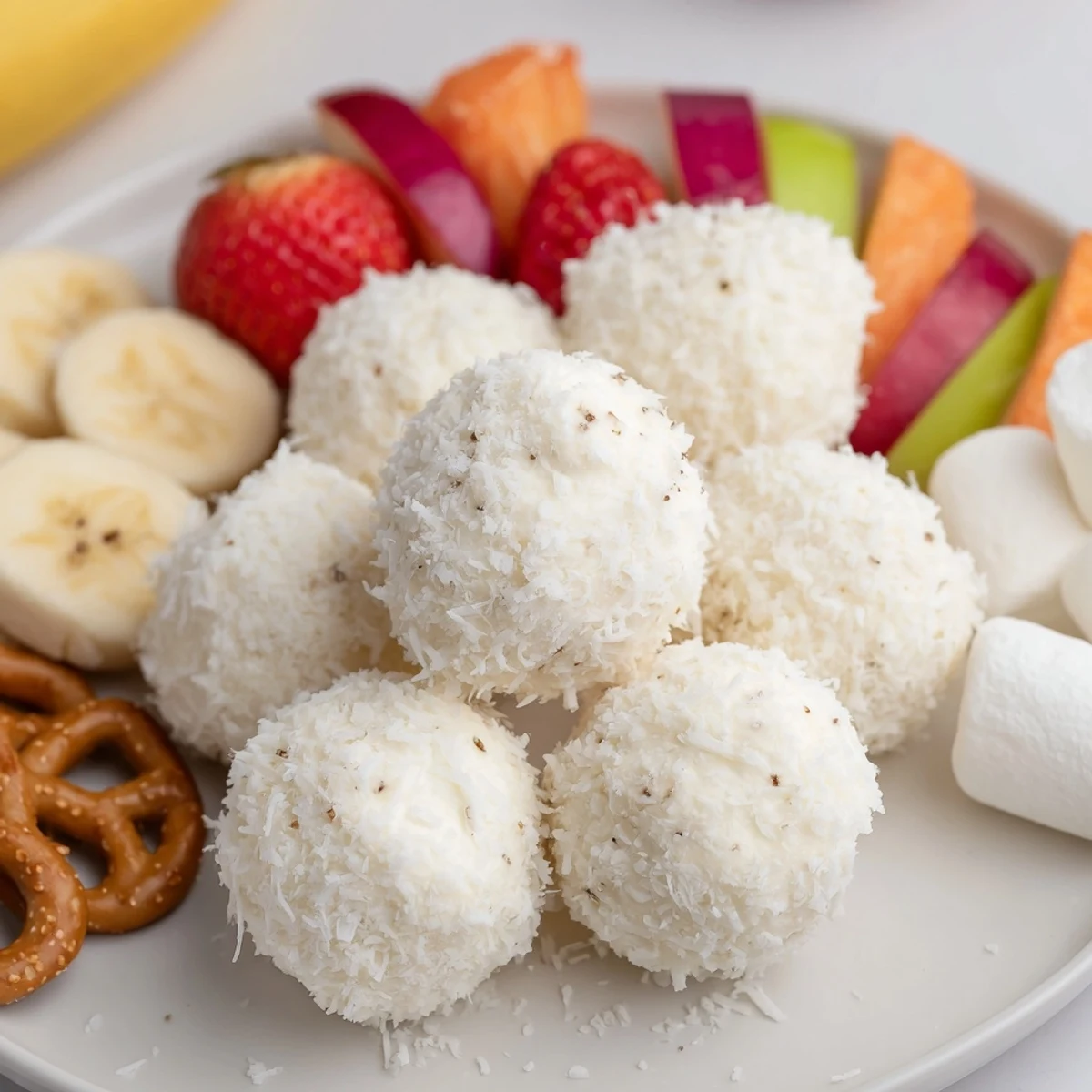 Creamy Marshmallow Snowball Dip Platter, a delightful dessert with coconut snowballs and fresh fruit.