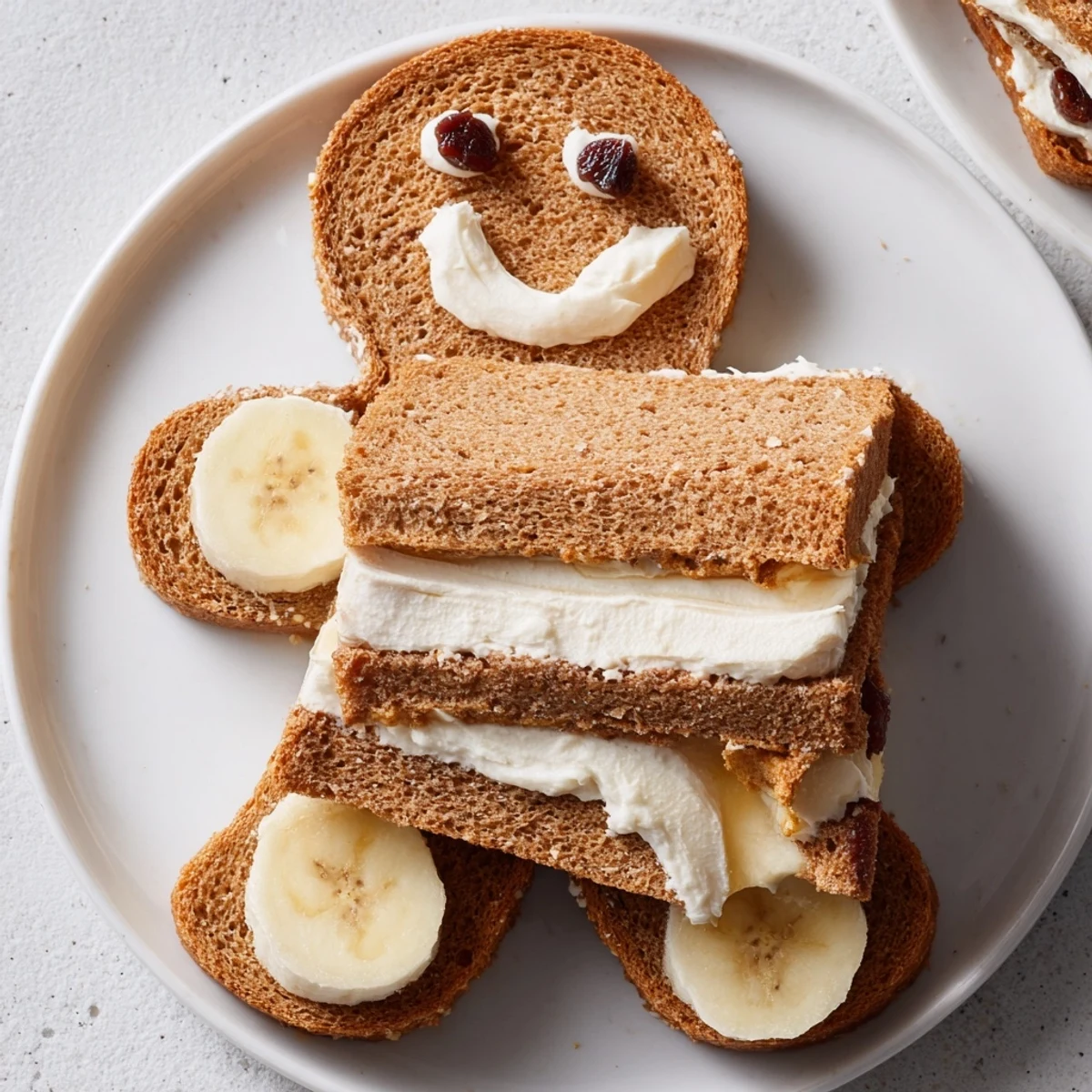 Gingerbread man sandwich cutouts with cream cheese and fruit, a fun, festive snack.