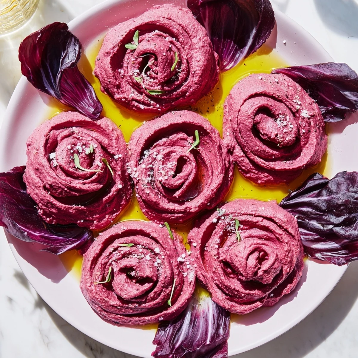 Vibrant beet hummus roses, part of The Velvet Rose appetizer, are served with crisp, fresh radicchio.