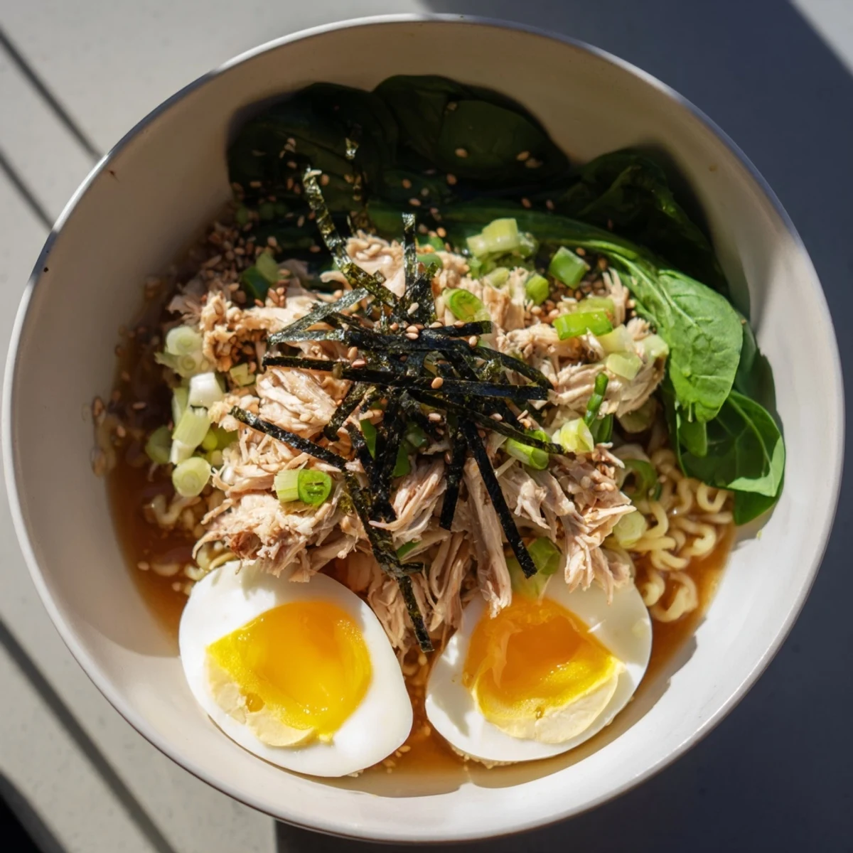 Golden soft-boiled egg tops this creamy Chicken Ramen, swirled with Kewpie mayo and green scallions.