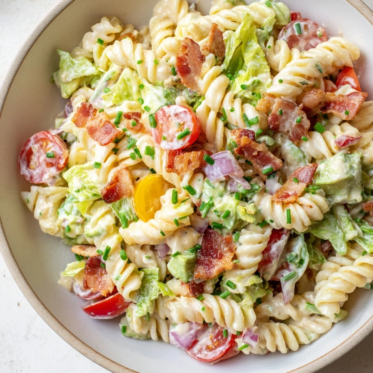 Creamy BLT Pasta Salad features al dente pasta with bacon and juicy tomatoes, tossed in a flavorful sauce.