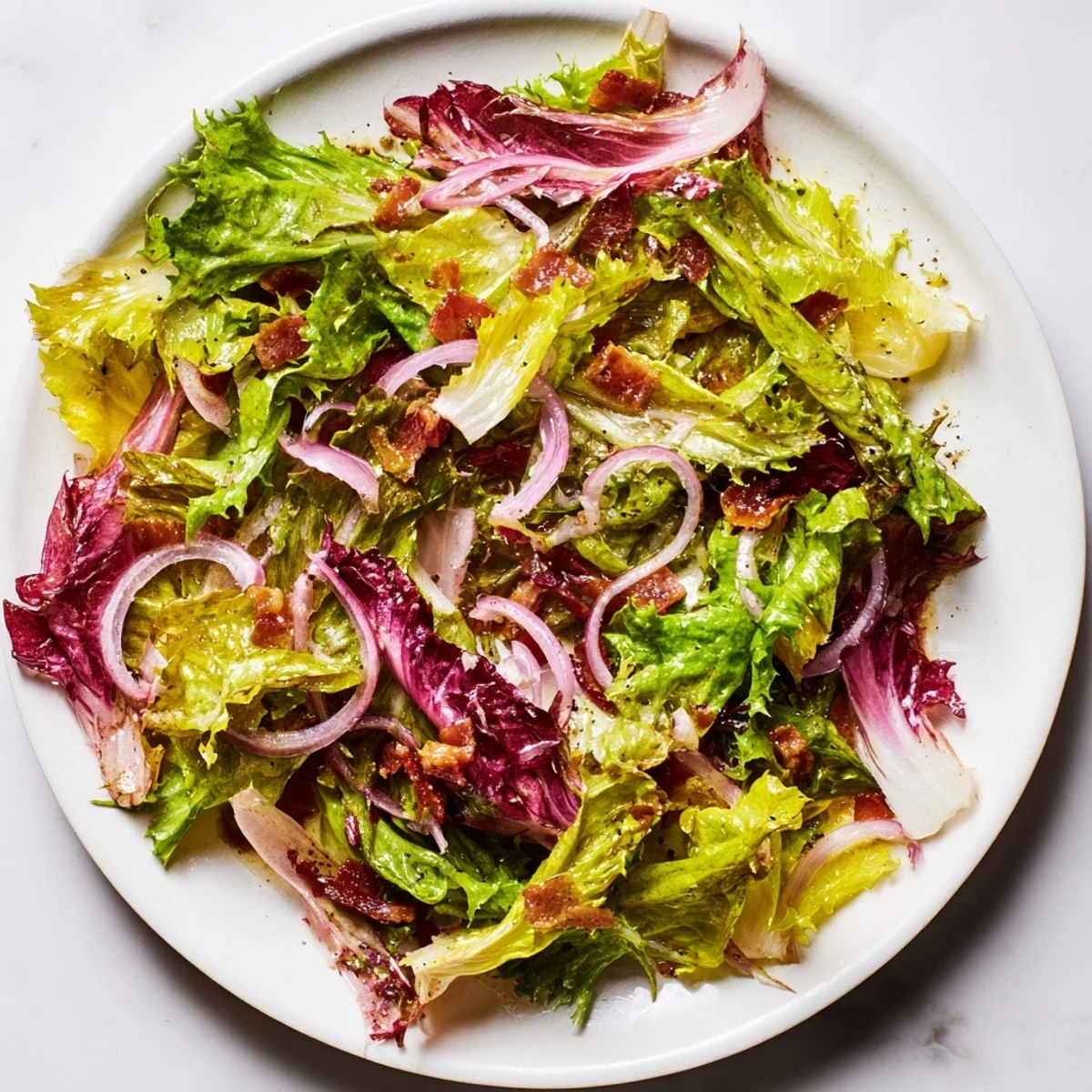 Tossed Bitter Greens Salad with Warm Bacon Dressing, featuring wilted greens and smoky bacon goodness.