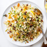 Fluffy Couscous Pilaf Spiced with warm cinnamon and cumin, garnished with parsley and lemon wedges.