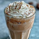 Creamy vanilla bean frappuccino protein shake with frothy almond milk, Greek yogurt, and vanilla bean seeds—perfect for a healthy, post-workout treat.