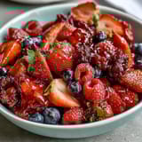 A colorful spring fruit platter with strawberries, pineapple, and kiwi, served with creamy honey-yogurt dipping sauce for a fresh, healthy snack.