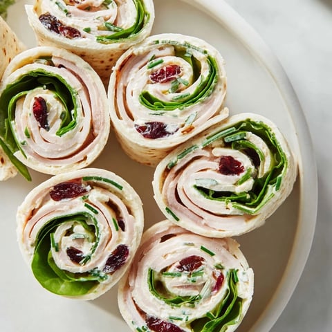 Delicious, festive Simplified Turkey Cranberry Pinwheels, layered with cranberry and turkey, ready to eat!