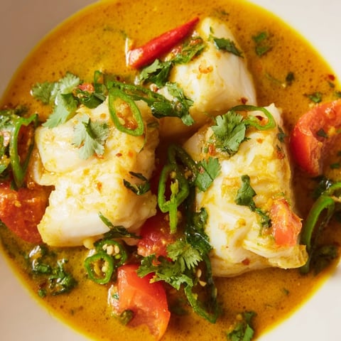 Steaming Bahraini Fish Curry with flaky white fish in a rich, spiced coconut milk broth, ready to serve.