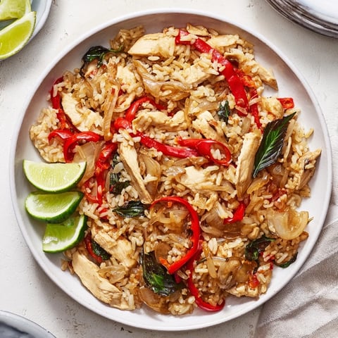 Spicy Thai Basil Chicken Fried Rice with tender chicken, chilies, and holy basil served with lime and cucumber.