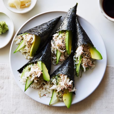 Sushi Rice Hand Rolls with creamy avocado and crisp cucumber, rolled in nori for a fresh, handheld Japanese treat.