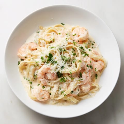 A close-up view of steaming Instant Pot Shrimp Alfredo Pasta, ready in just 20 minutes.