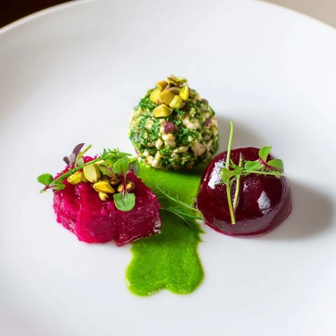 Elegant Lucky Clover Seasonal Starters plated with vibrant green pea puree, beets, and creamy goat cheese.