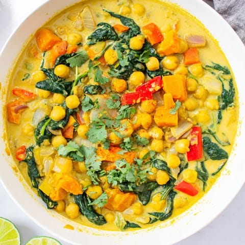 A steaming bowl of flavorful Chickpea Curry, showcasing tender chickpeas and colorful peppers.