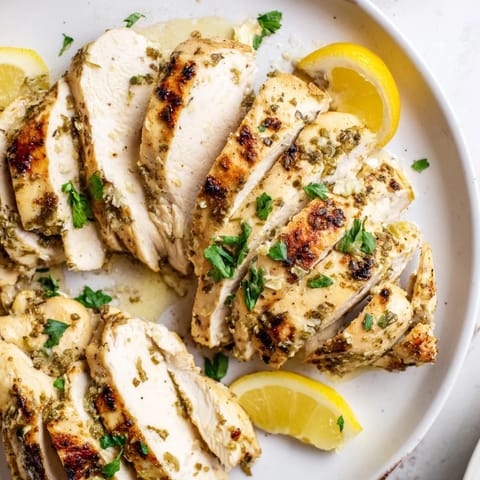 Juicy Greek Yogurt Chicken breasts, infused with garlic and herbs, presented on a white platter for serving.