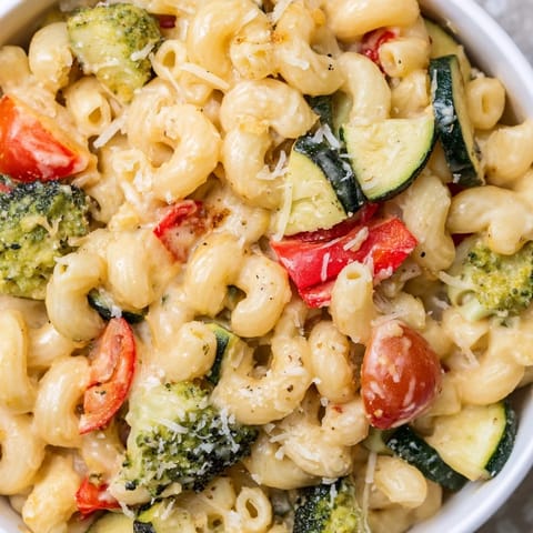 Fork-ready Roasted Veggie Mac & Cheese with bright peppers and broccoli in a rich sauce.
