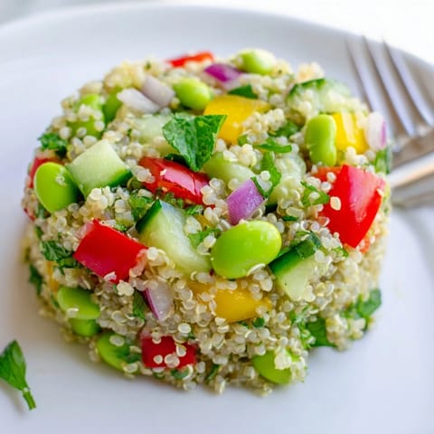 Topped with fresh parsley and mint, this protein-rich Edamame and Quinoa Salad offers a refreshing crunch perfect for healthy lunches.