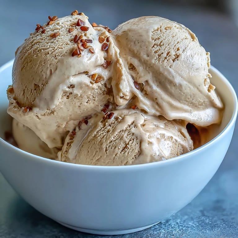 Rich, roasted Hojicha Ice Cream is served in a waffle cone against a rustic wooden background.