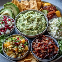 Vibrant guacamole bar with five fresh toppings, perfect for a Mexican fiesta.